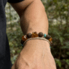 Amber Dawn & Agarwood Earthheart Bracelet – Pangu Edition Outdoor Wear Amber Dawn and Agarwood Earthheart Bracelet Pangu Edition worn on men’s wrist in natural outdoor setting