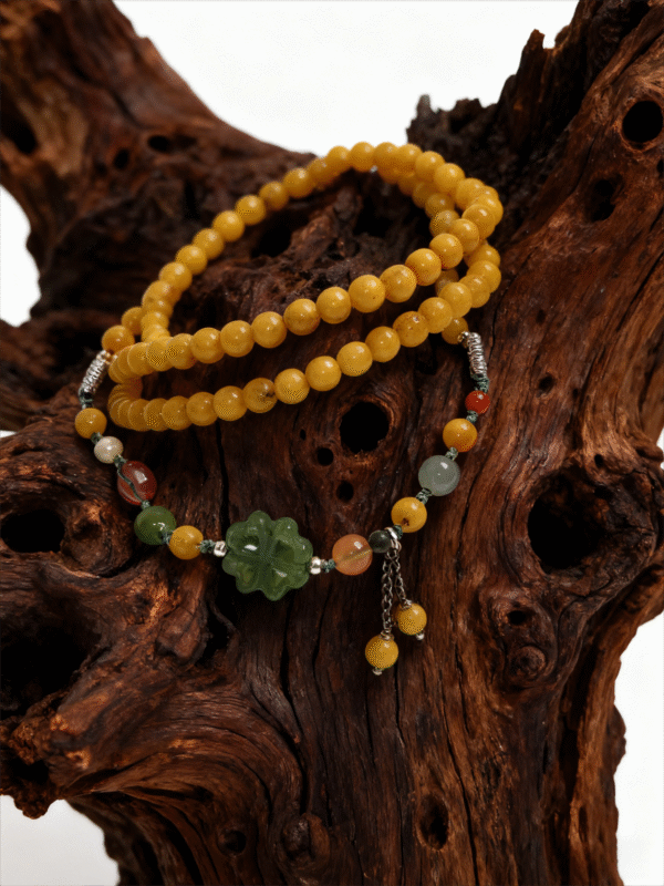 Amber Dawn Genesis Bracelet – Pangu Edition (5mm) with golden amber beads and green jade charm displayed on a natural wooden background