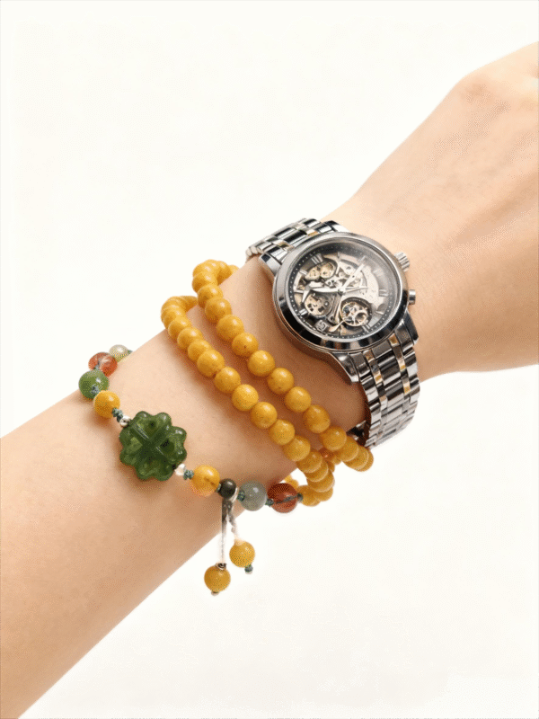 Amber Dawn Genesis Bracelet – Pangu Edition (5mm) worn on the wrist with a stainless steel watch, featuring golden amber beads and a green jade Pangu motif