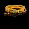 Amber Dawn Genesis Bracelet inspired by Pangu, featuring yellow agate beads in a double-wrap design with a carved green jade centerpiece, photographed on a black background