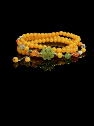 Amber Dawn Genesis Bracelet inspired by Pangu, featuring yellow agate beads in a double-wrap design with a carved green jade centerpiece, photographed on a black background