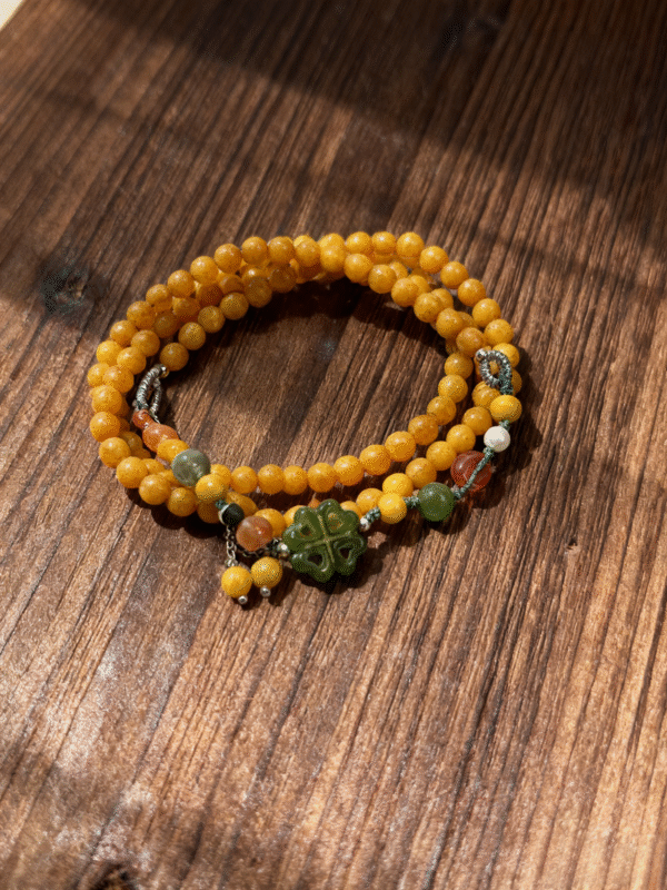 Amber Dawn Genesis Bracelet – Pangu Edition (5mm) featuring layered amber beads and jade centerpiece displayed on sculptural driftwood