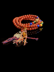 Xingtian inspired Bound Resolve red agate bracelet (10mm) in a multi-wrap design with red round beads, colorful accent beads and tassel charms on a black background