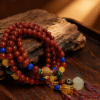 Bound Resolve Red Agate Bracelet 10mm – Xingtian Inspired Warm Wood Scene Detail Shot Bound Resolve red agate bracelet (10mm) in a multi-wrap style displayed on a wooden tray under warm lighting, highlighting the red beads and tassel accessories