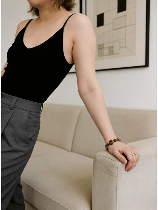 Woman wearing the Crimson Seal & Jade Grove Bracelet – Shennong Edition (10mm) in an indoor setting, featuring green jade beads and a carved crimson seal focal bead, blending traditional Eastern symbolism with modern everyday elegance