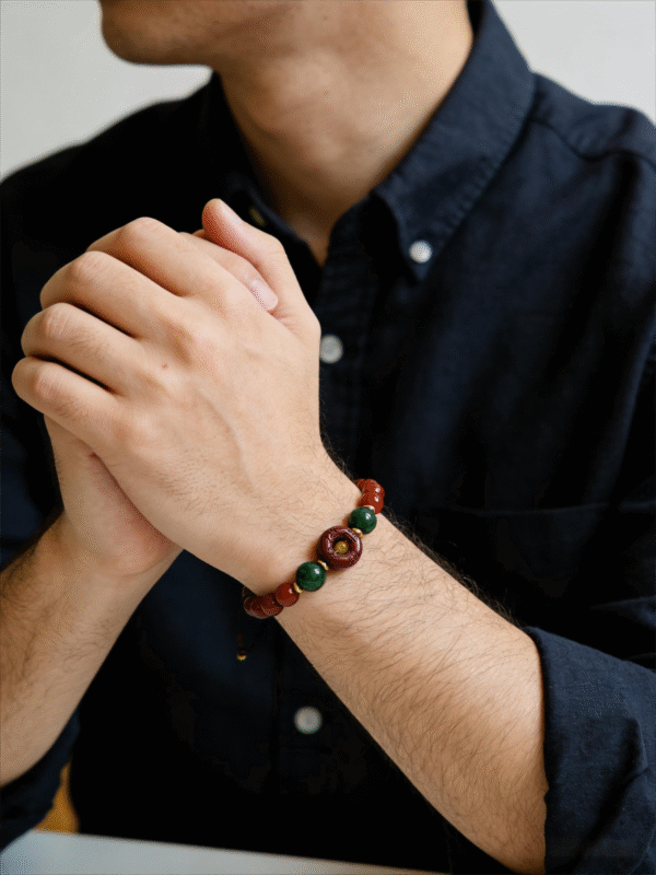 Crimson Seal & Jade Grove Bracelet – Shennong Edition (10mm) worn on the wrist, highlighting the contrast between polished green jade, crimson seal centerpiece, and gold accents, designed to embody harmony between strength, healing, and natural rhythm