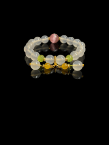 Goddess Moonstone and sunrise agate bracelet inspired by Chang’e, featuring smooth 10mm natural moonstone beads with sunrise agate accents and gold tone spacers on a black background