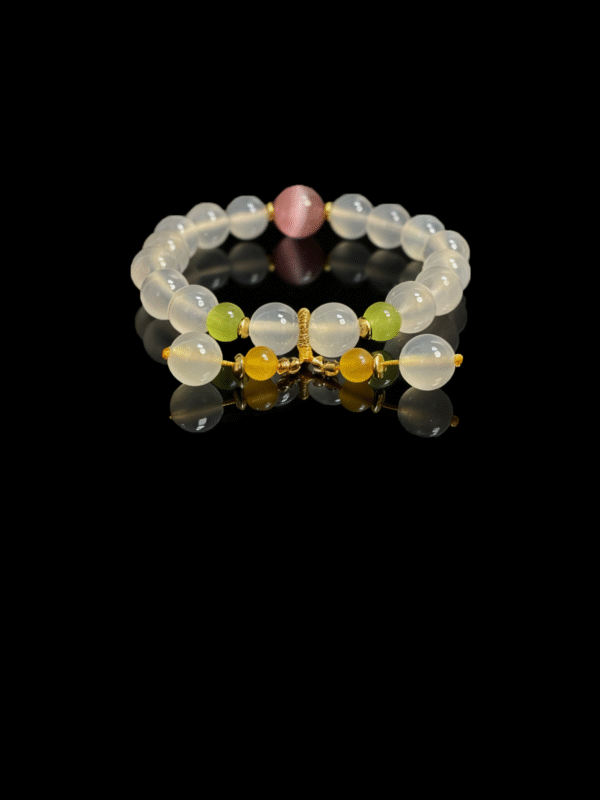 Goddess Moonstone and sunrise agate bracelet inspired by Chang’e, featuring smooth 10mm natural moonstone beads with sunrise agate accents and gold tone spacers on a black background