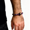 Men wearing the Nüwa inspired Mother of Earth bracelet (11mm) with purple beads, wood beads and gold details on a white background