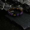 Nüwa inspired Mother of Earth bracelet (11mm) with purple beads, wood beads and gold spacers photographed on a dark stone background