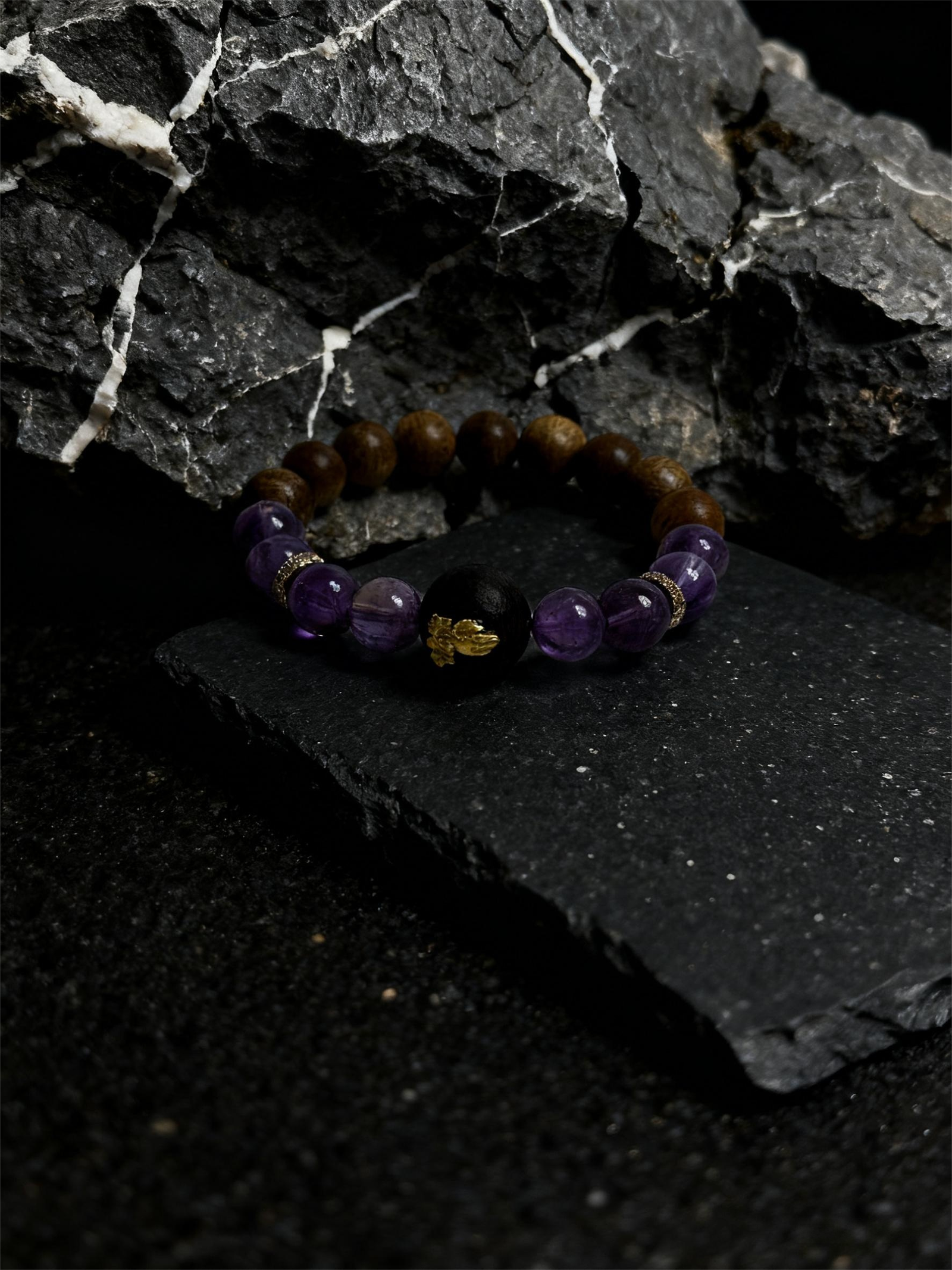 Nüwa inspired Mother of Earth bracelet (11mm) with purple beads, wood beads and gold spacers photographed on a dark stone background