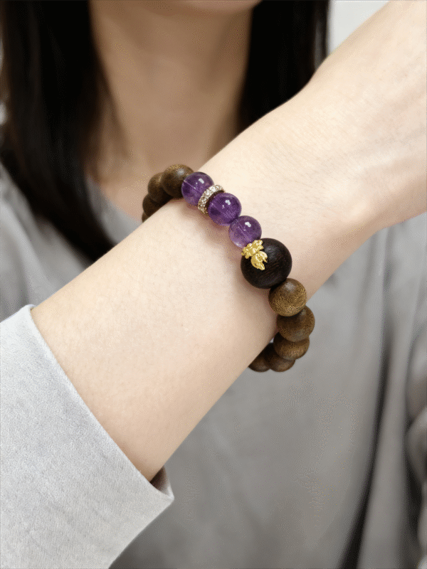 Close-up of the Nüwa inspired Mother of Earth bracelet (11mm) showing purple translucent beads, wood beads and gold spacer details