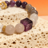 Nüwa Inspired Settled Order Bracelet – Purple Agate Detail Close-up of the Settled Order Bracelet inspired by Nüwa, highlighting the carved purple agate cube and smooth white gemstone beads on a stone surface