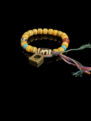 Product view of the Pangu’s Primordial Ethereal Bone-Agate Bracelet (10mm), featuring bone-tone agate beads, a colorful braided tassel cord and a geometric gold charm on a black background