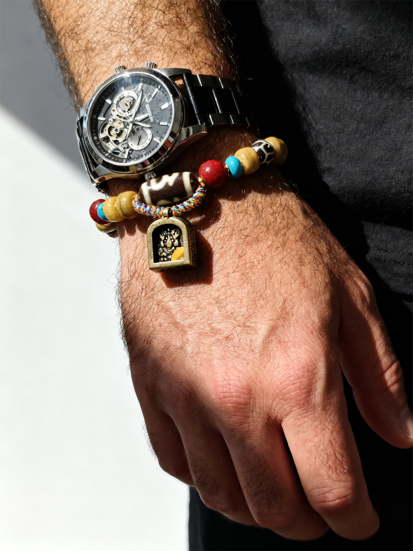 Man wearing Pangu’s Primordial Ethereal Bone-Agate Bracelet with mechanical watch, showing bone and agate beads and symbolic amulet