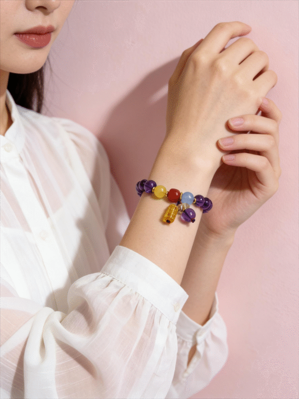 Close-up of the Nüwa inspired Reforged Harmony Bracelet (11mm) featuring purple beads with yellow red blue accent beads and a charm in soft light