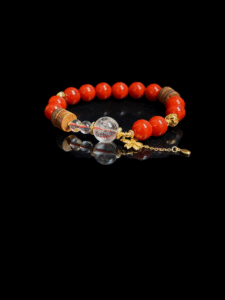 Unbroken Core red agate bracelet inspired by Xingtian, featuring 10mm natural red agate beads with clear quartz and gold accents on a black background