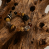 Handmade Watchful Relic agate bracelet (12–15mm) with mixed gemstone beads and statement centerpiece, displayed on rustic carved wood, bold unisex spiritual jewelry style
