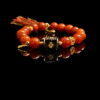 Xingtian’s Scarlet Agate Bracelet featuring polished 10mm red agate beads and a central emblem charm, displayed on a black background with reflective surface.