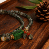 Close-up of Harmonizing Green Agate Bracelet Shennong Inspired 6mm featuring carved green agate centerpiece and natural stone beads on wooden tray