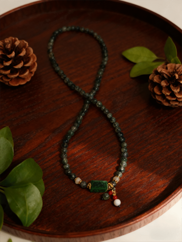 Full view of Harmonizing Green Agate Bracelet Shennong Inspired 6mm displayed on wooden tray with natural botanical elements