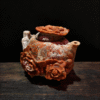 hand-carved stone collectible titled Blooming Prosperity Teapot, featuring a teapot form adorned with blooming floral motifs carved from natural stone