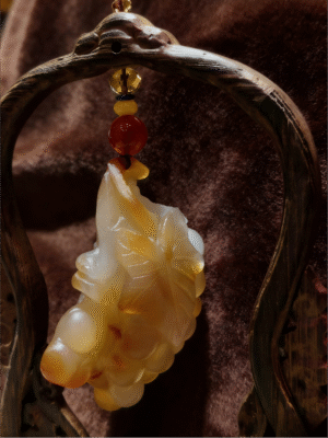 hand-carved stone collectible titled Golden Harvest Grapes, featuring a hanging grape cluster motif carved from natural stone