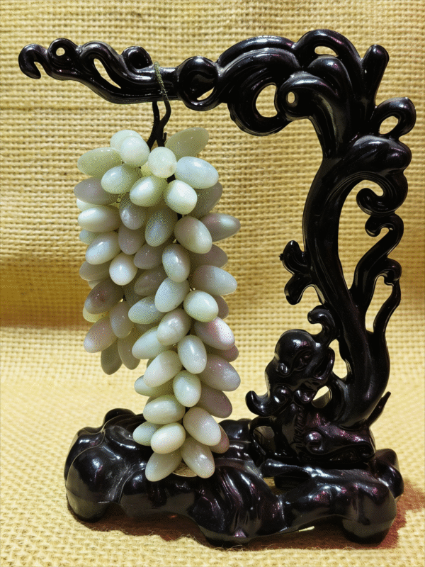 Hanging Grapes of Abundance – Hand-carved Mineral Collectible hand-carved mineral collectible titled Hanging Grapes of Abundance, featuring a cluster of grape-shaped stone beads suspended from a sculptural carved stand