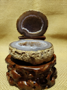 natural mineral collectible titled Inner Cosmos, featuring a sliced geode with an exposed crystal interior displayed on a carved stand