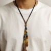 Primordial Layered Agate & Dzi pendant necklace worn over a white T-shirt, showcasing natural agate layers, traditional Dzi bead, and hand-tied tassel details