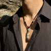 Primordial Layered Agate Pendant Necklace – Pangu Inspired Outdoor Styling Outdoor lifestyle shot of the Primordial Layered Agate Pendant Necklace worn by a male model, showcasing the raw layered agate pendant and traditional bead details inspired by the Pangu legend