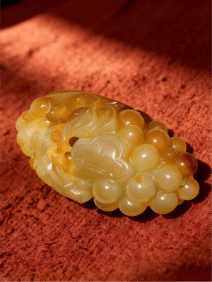 Handheld Agate Artwork titled Ring of Abundance, featuring a rounded, bead-like sculptural form carved in translucent golden agate