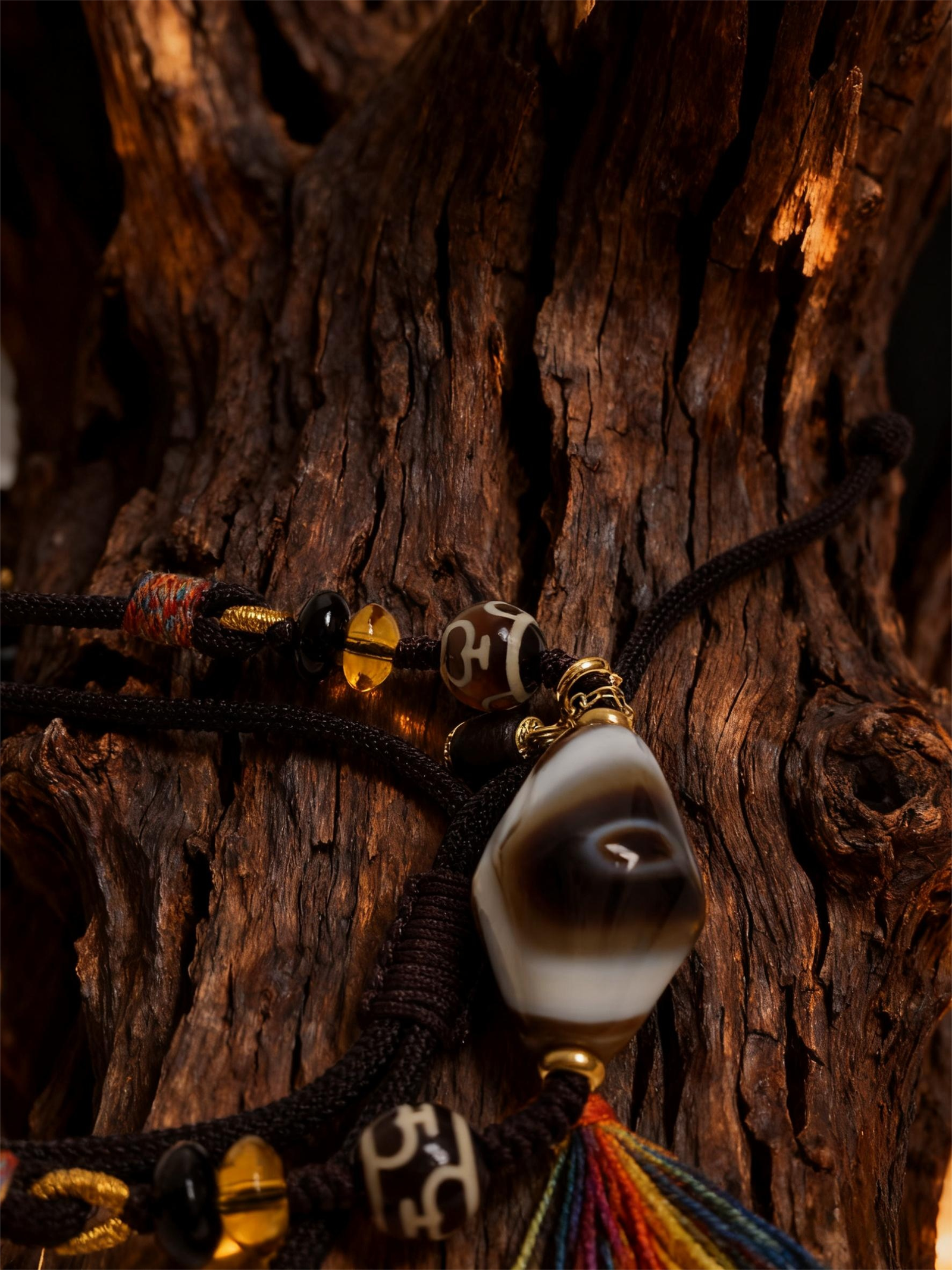 Turbulent Layered Agate & Dzi pendant necklace inspired by Gonggong, featuring a layered agate bead and traditional dzi element displayed on natural wood