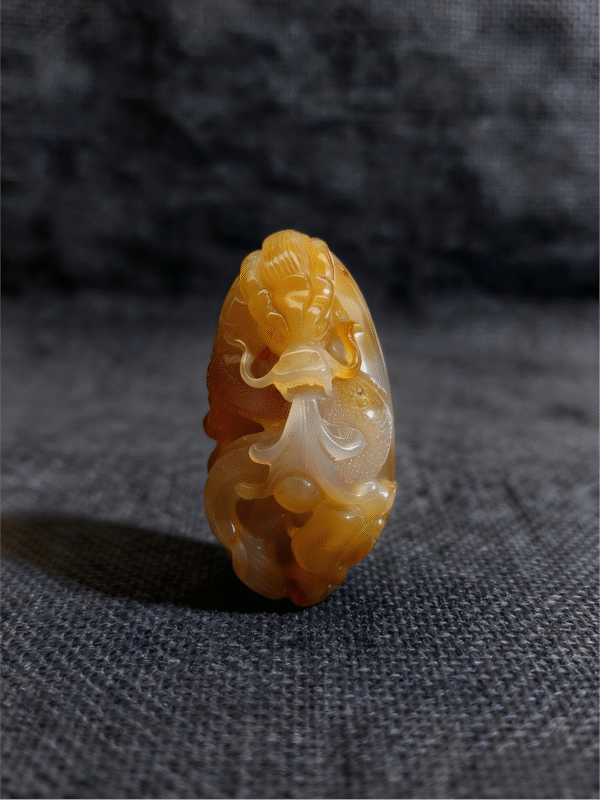Amber Warden – Handheld Agate Artwork handheld agate artwork titled Amber Warden, carved from natural agate stone as a compact guardian-style collectible sculpture