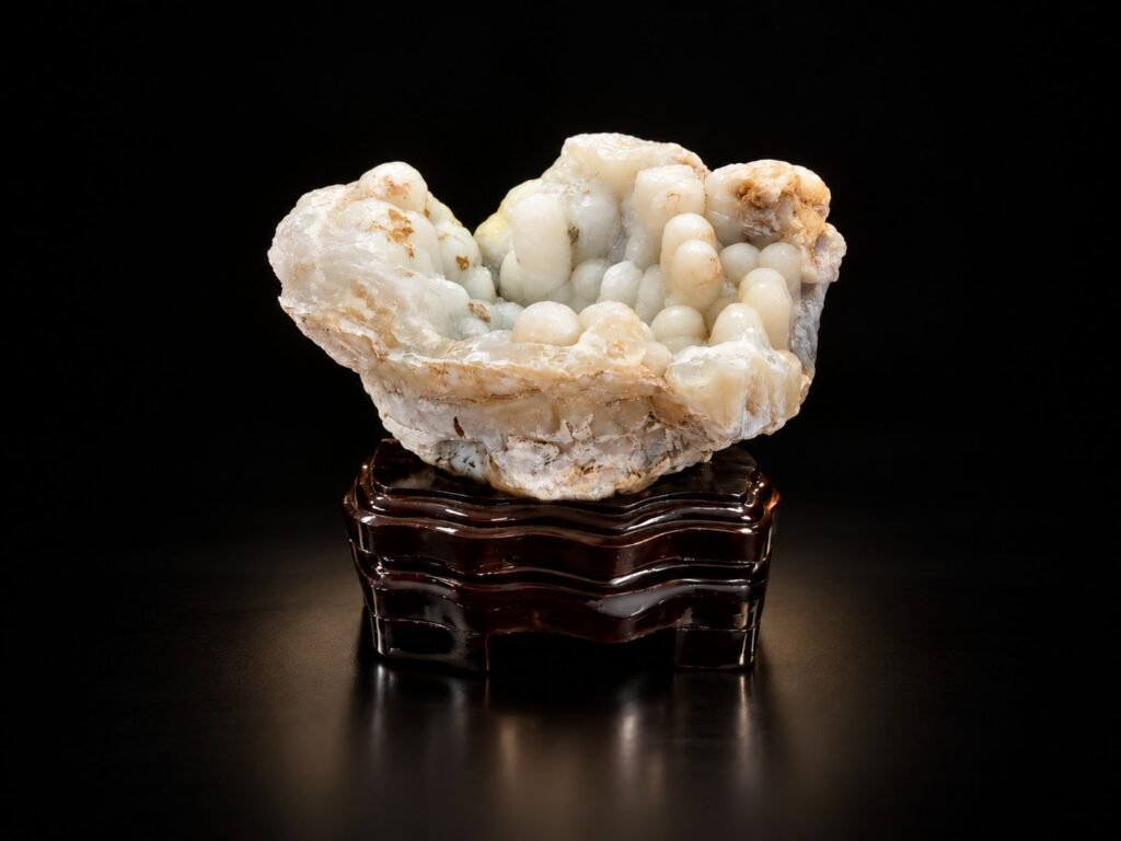 Natural agate collectible with creamy white crystal formation on a dark wooden stand