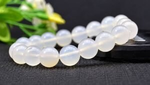 Translucent white agate bead bracelet with polished round beads on a dark background.