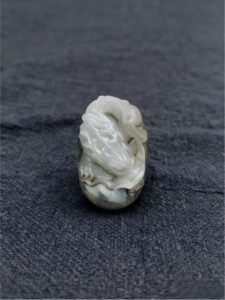 handheld agate artwork titled Ivory Coil Dragon, carved from natural agate stone as a coiled dragon collectible sculpture