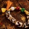 Gonggong’s Turbulent Elements Dzi Bead Bracelet with Agate, Jade & Beeswax Amber(12mm) Gonggong-inspired beaded bracelet featuring Dzi beads, agate, jade, beeswax amber, and multicolored woven cord.