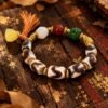 Gonggong’s Turbulent Elements Dzi Bead Bracelet with Agate, Jade & Beeswax Amber(12mm) Gonggong-inspired beaded bracelet featuring Dzi beads, agate, jade, beeswax amber, and multicolored woven cord.